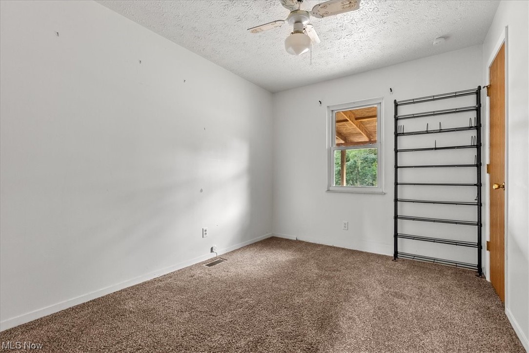 1827 Barth Road Belpre, OH 45714 - Photo 20 of 31 Spare room with a textured ceiling, carpet, and ceiling fan