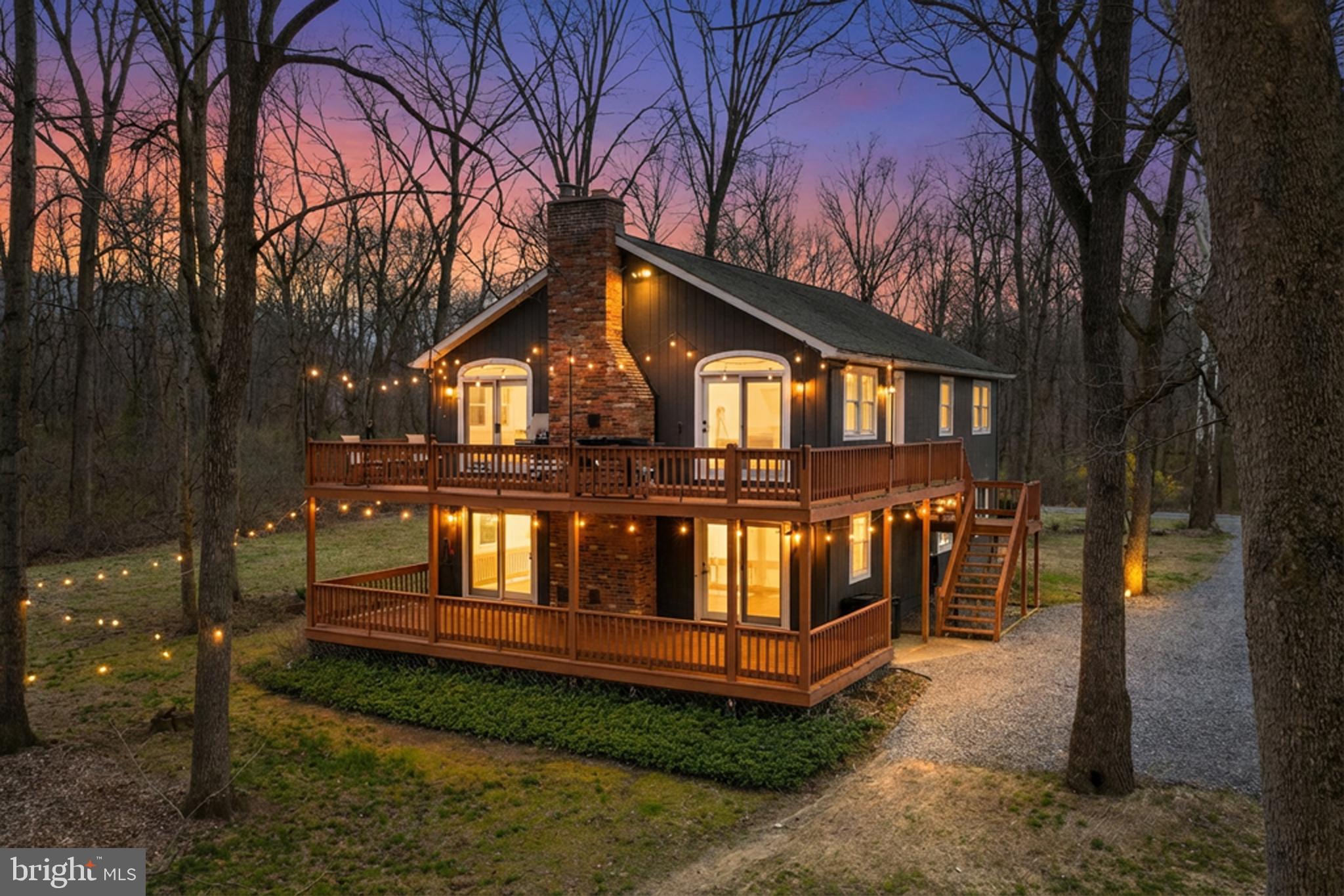 a front view of a house with yard and trees