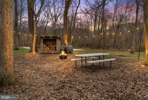 a view of a backyard with lawn chairs and a fire pit
