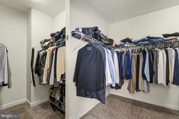 a living room with furniture a flat screen tv and a refrigerator