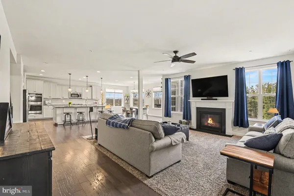 a kitchen with stainless steel appliances granite countertop a sink a stove a refrigerator and chairs