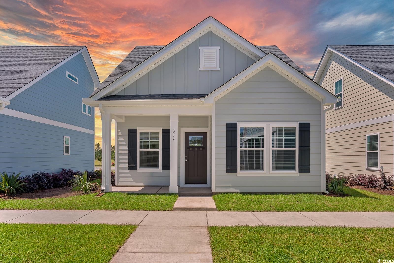 View of front of house featuring board and batten siding, a porch, and a front lawn