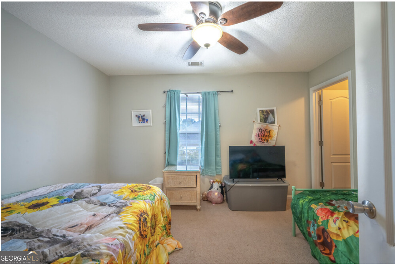 59 Laurel Way Ludowici, GA 31316 - Photo 16 of 21 a bedroom with a bed a flat screen tv and a window