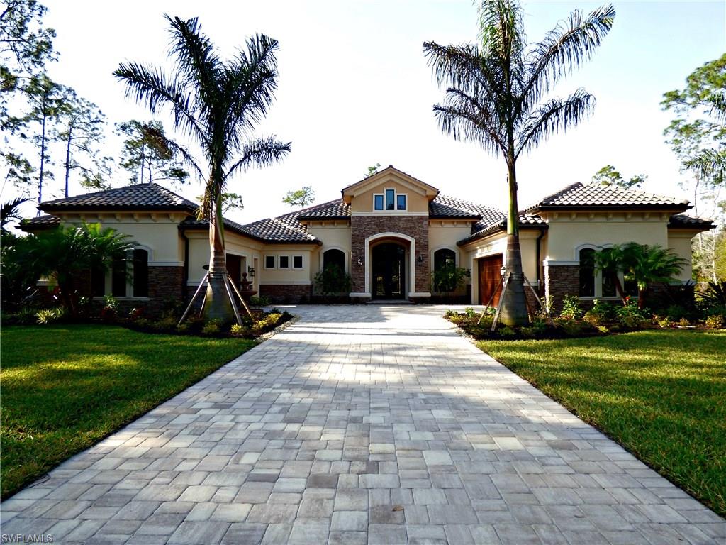 a front view of a house with a garden and trees