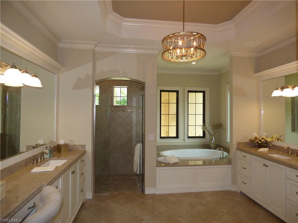 6376 Burnham Road Naples, FL 34119 - Photo 12 of 23 a spacious bathroom with a granite countertop tub a double vanity sink and a chandelier