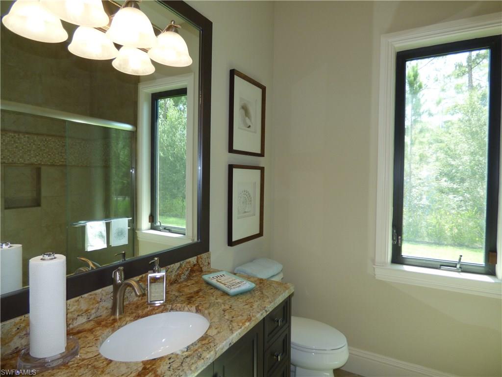 6376 Burnham Road Naples, FL 34119 - Photo 18 of 23 a bathroom with a granite countertop sink vanity mirror and toilet