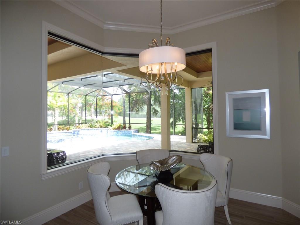 6376 Burnham Road Naples, FL 34119 - Photo 6 of 23 a dining room with furniture a chandelier and wooden floor