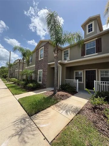 a front view of a house with a yard and potted plants