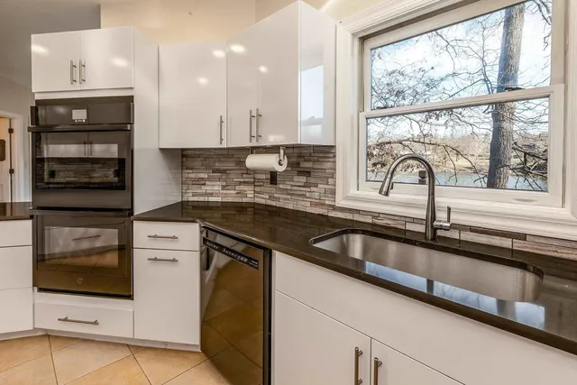 a kitchen with stainless steel appliances kitchen island granite countertop a stove and a refrigerator