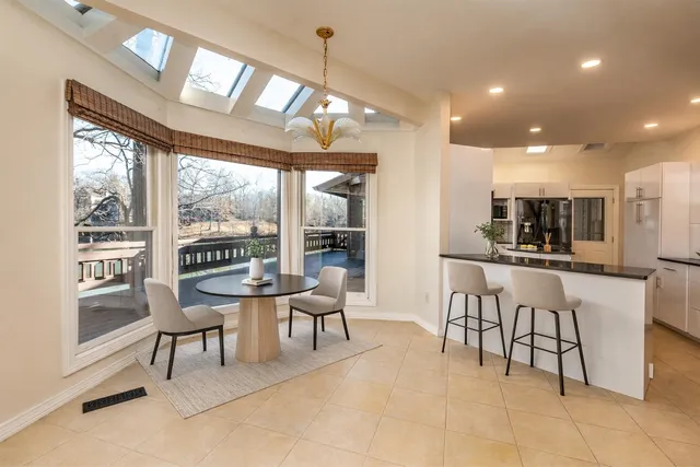 a view of a dining room with furniture a chandelier and wooden floor