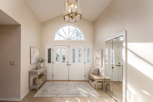 a spacious bedroom with a large bed and three large window