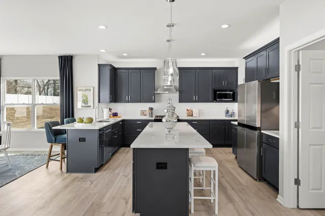 a large kitchen with a large counter top a sink stainless steel appliances and cabinets