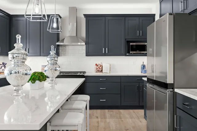 a kitchen with stainless steel appliances granite countertop a sink and a refrigerator
