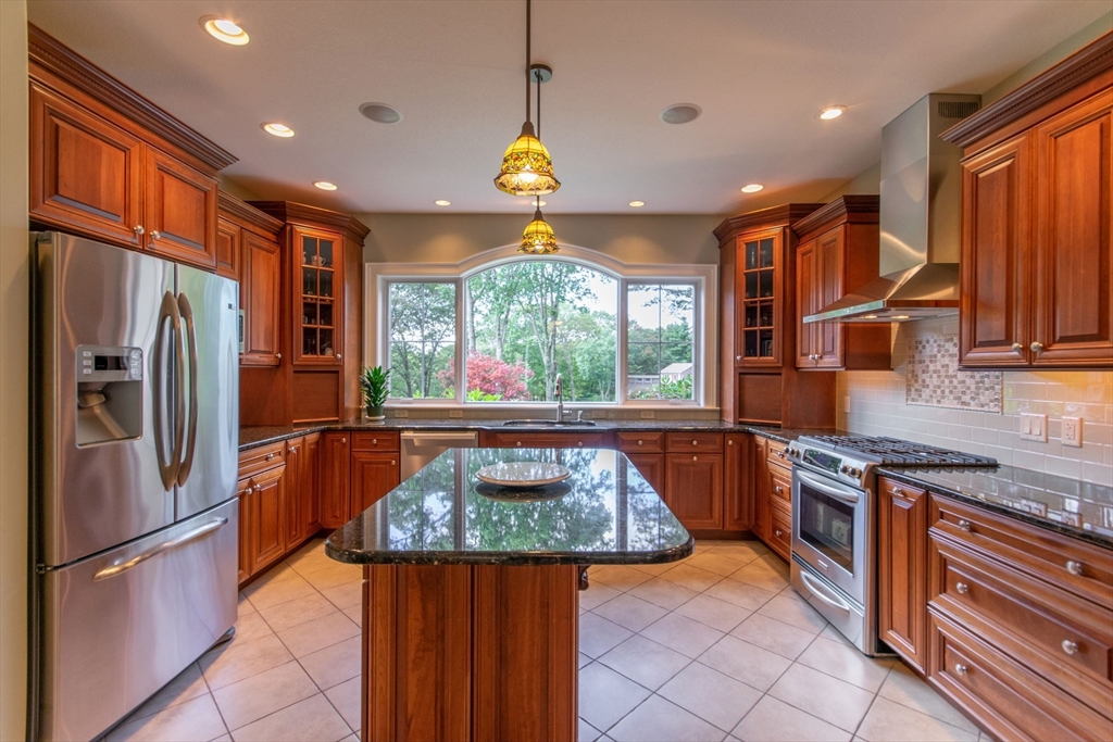 7 Western View Road Holyoke, MA 01040 - Photo 13 of 42 a kitchen with stainless steel appliances granite countertop a refrigerator a sink dishwasher a stove and a dining table with wooden floor