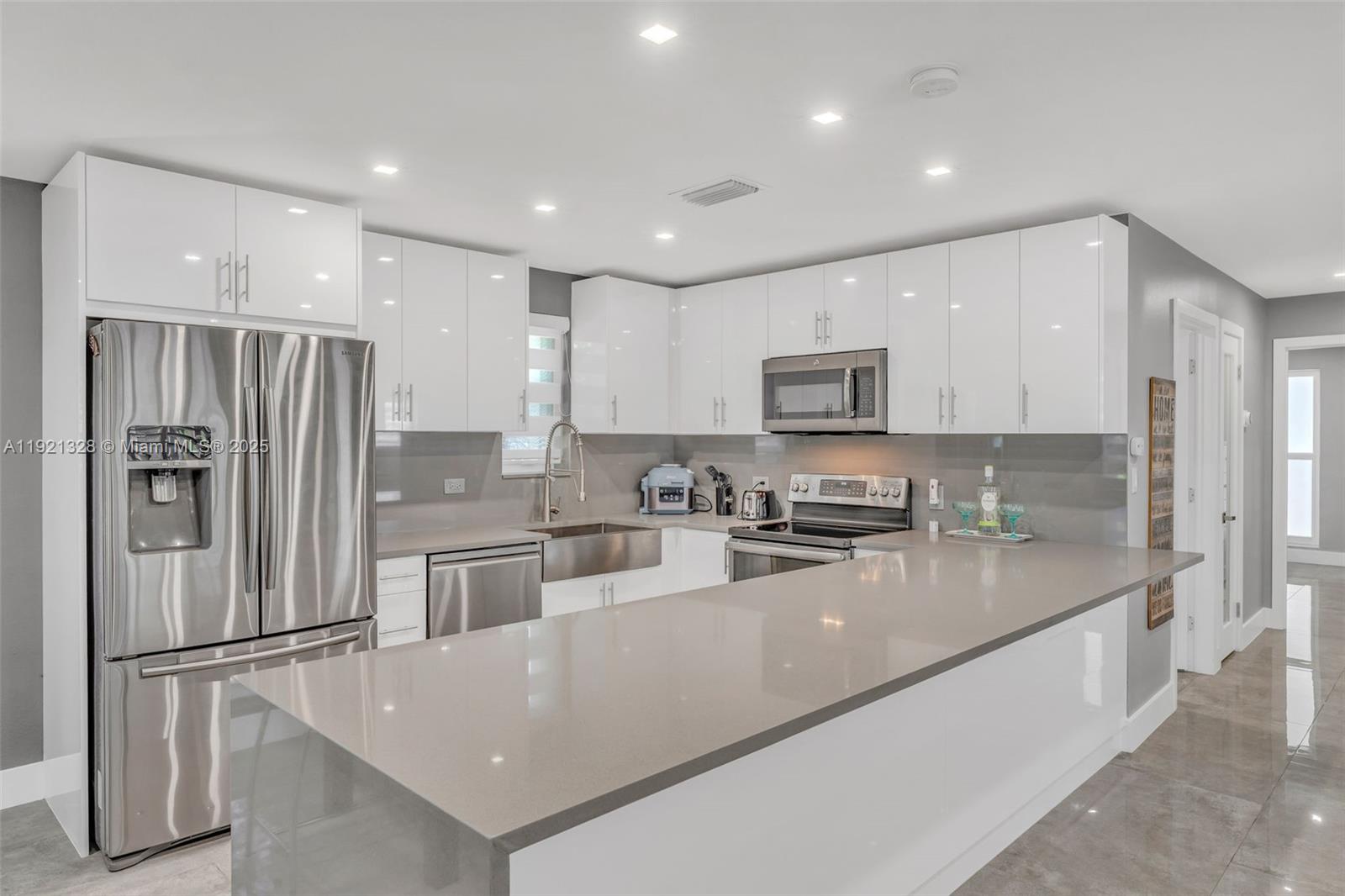 222 2nd Road Key Largo, FL 33037 - Photo 11 of 43 a kitchen with stainless steel appliances granite countertop a refrigerator a stove a sink a microwave and cabinets