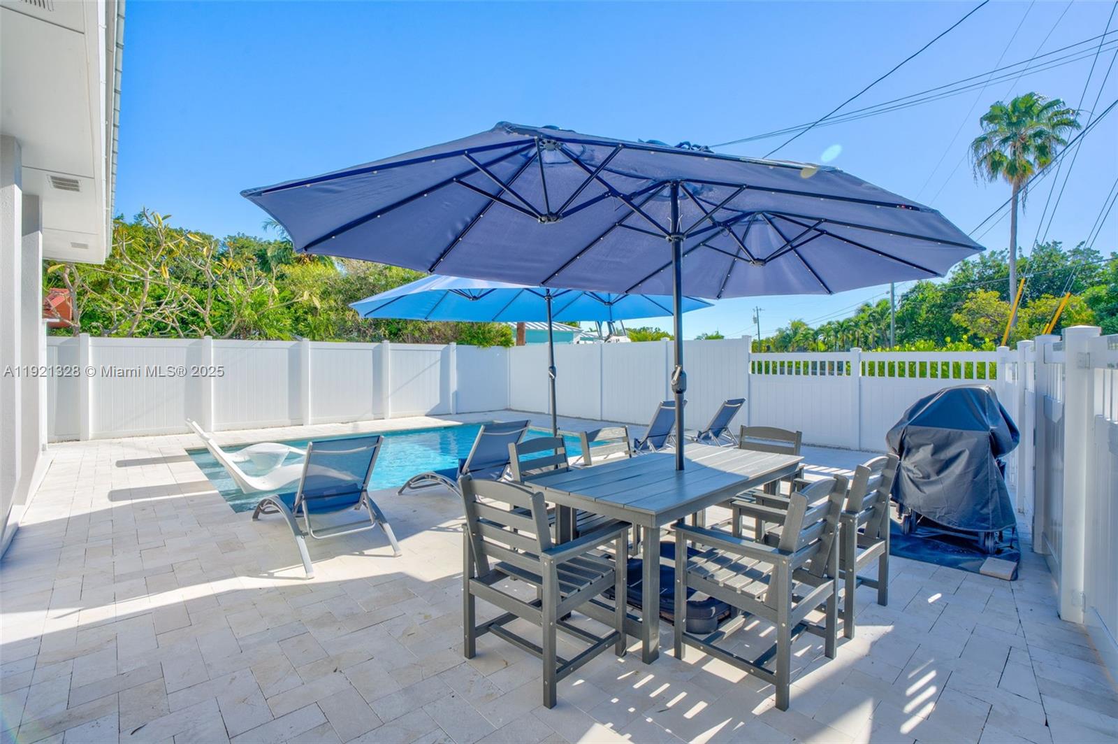 222 2nd Road Key Largo, FL 33037 - Photo 31 of 43 a patio with a table and chairs under an umbrella