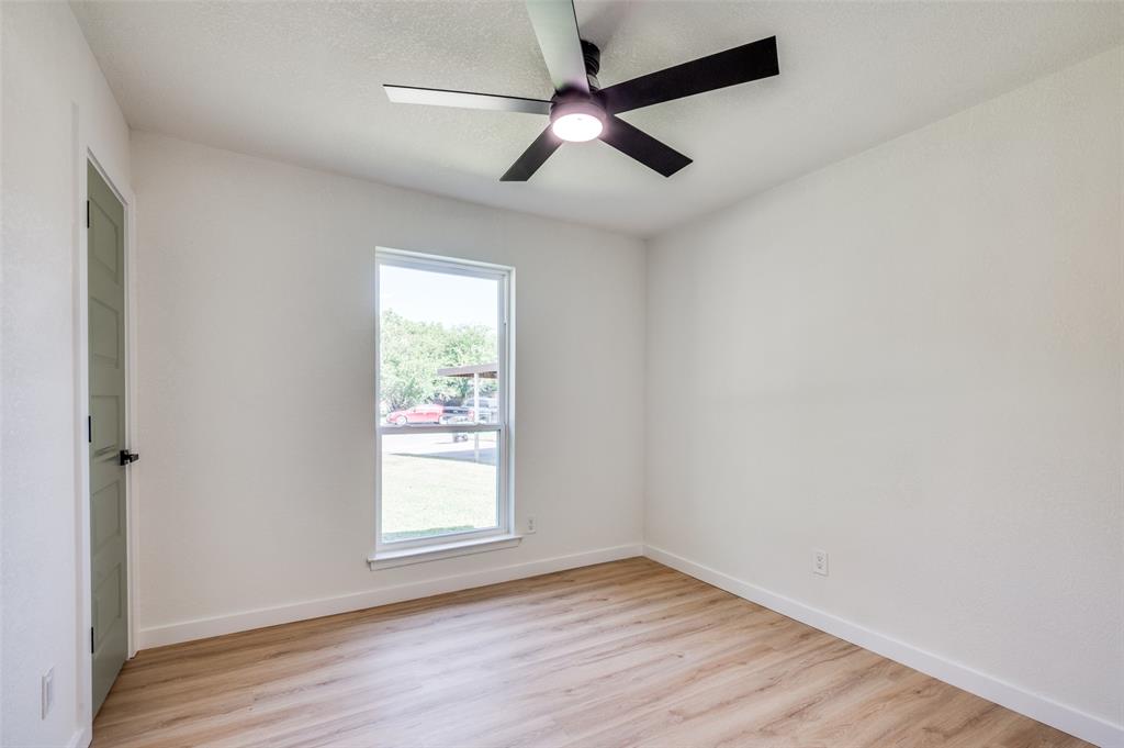 509 Steeple Ridge Court Everman, TX 76140 - Photo 9 of 21 Unfurnished room featuring light wood-type flooring, ceiling fan, and a textured ceiling