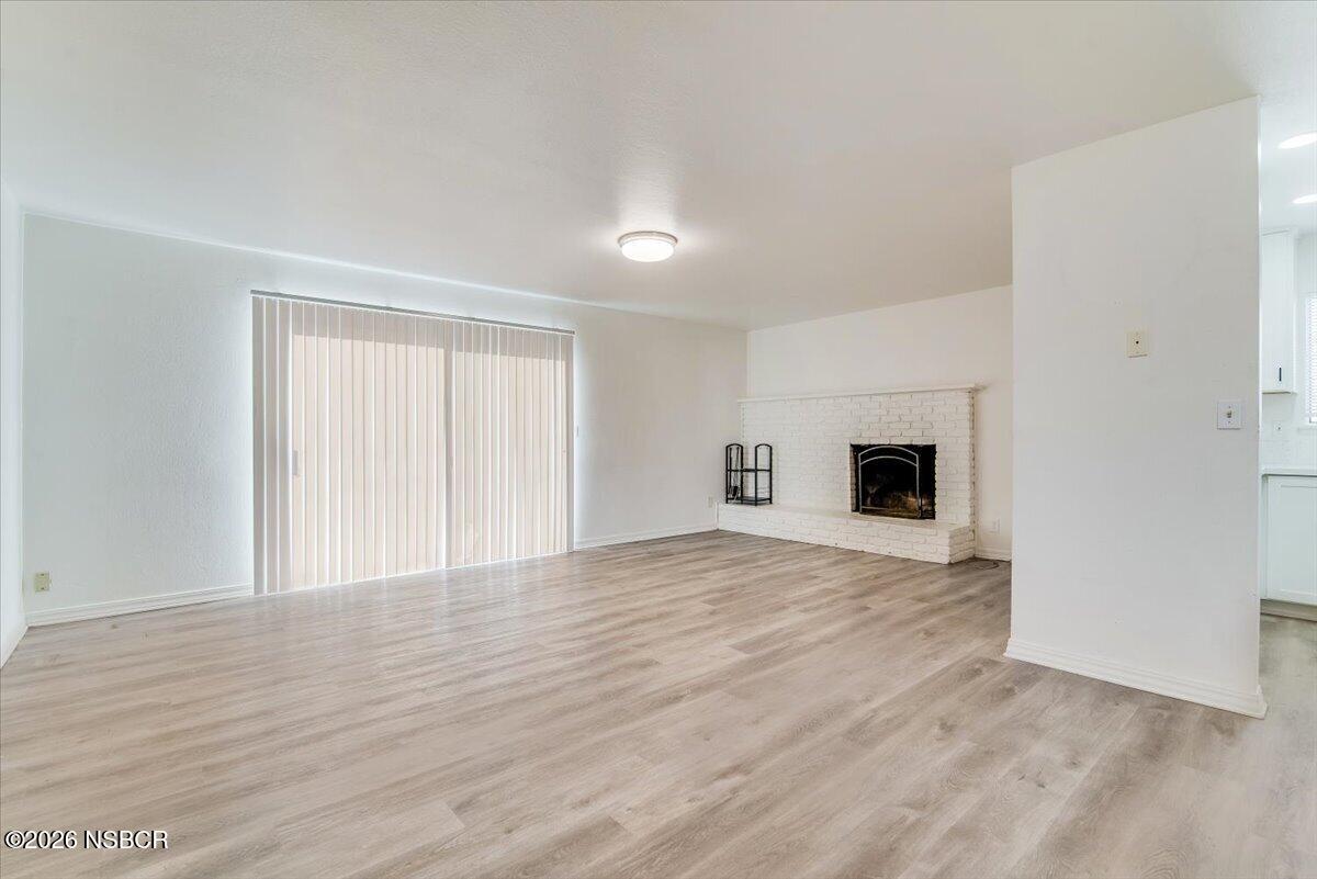 321 North Z Street Lompoc, CA 93436 - Photo 4 of 33 a view of empty room with wooden floor and fireplace