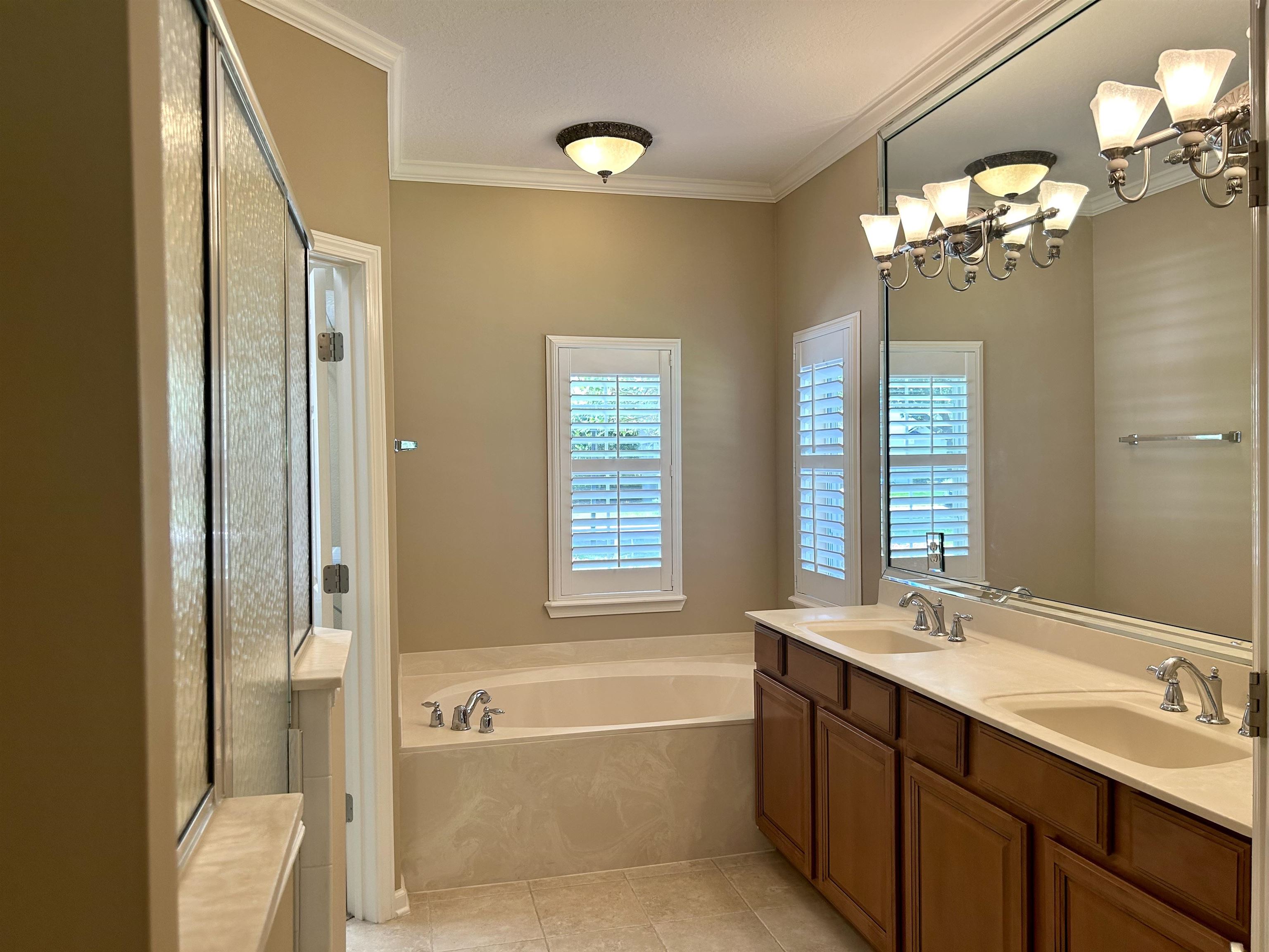 3844 Paddington Place St. Augustine, FL 32092 - Photo 11 of 40 a spacious bathroom with a double vanity sink a large mirror and a bathtub with shower