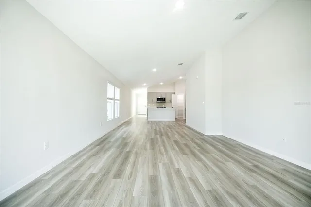 a view of empty room with wooden floor