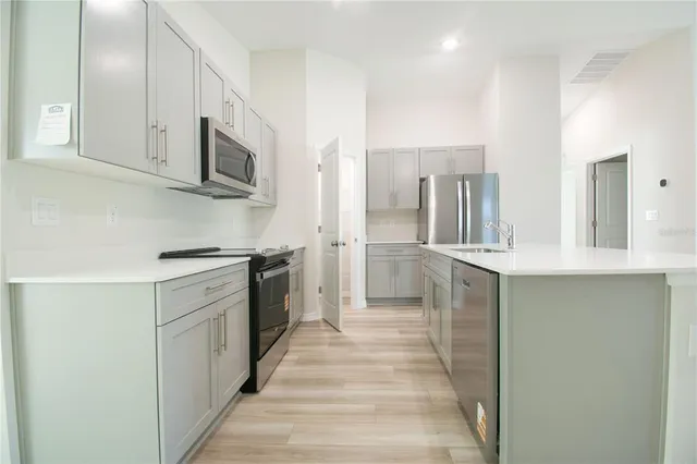 a kitchen with stainless steel appliances a sink and a microwave