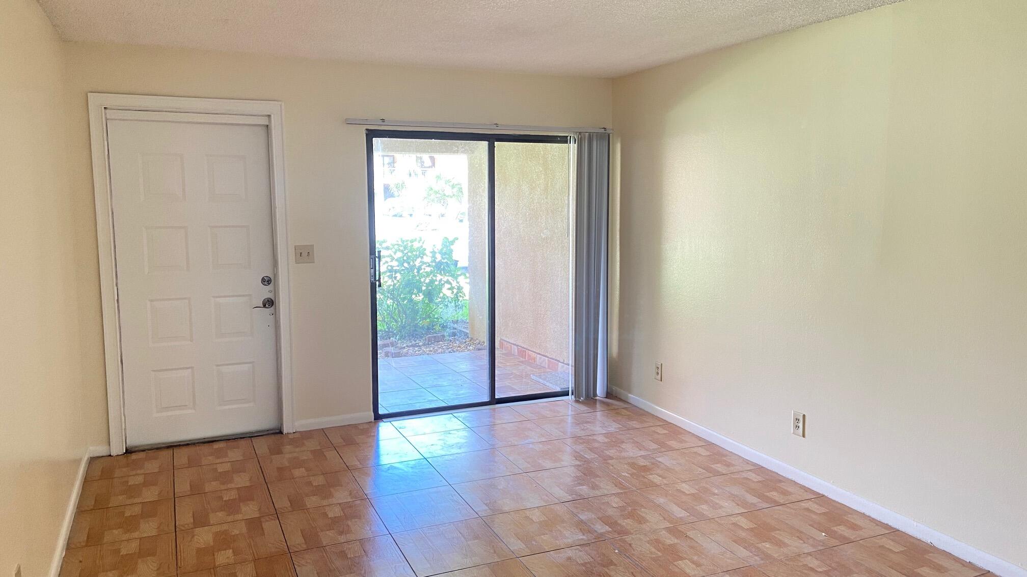 5935 Forest Hill Boulevard, Unit 8 West Palm Beach, FL 33415 - Photo 2 of 6 an empty room with sliding door