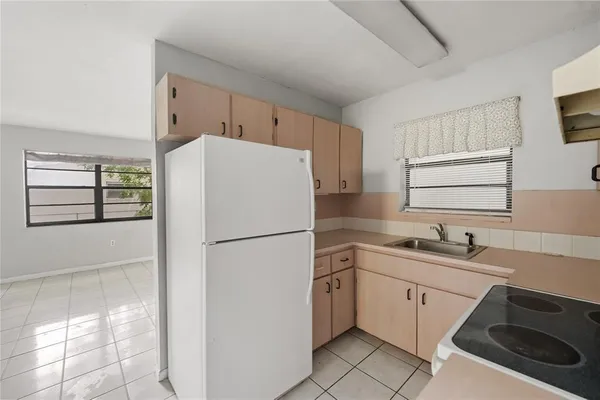 a white refrigerator freezer sitting in a kitchen with white cabinets