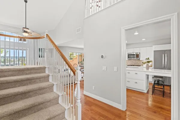 a view of staircase and kitchen with wooden floor