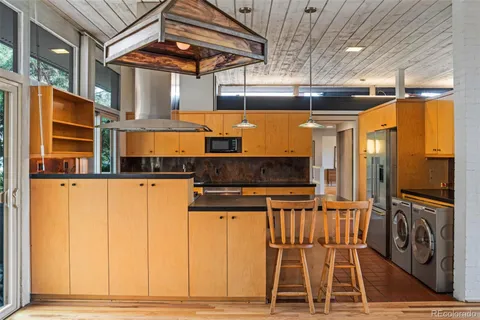 a kitchen with granite countertop a sink a counter top space and stainless steel appliances