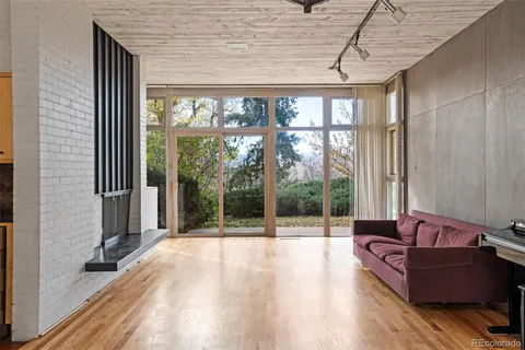 a living room with furniture a wooden floor and next to a window