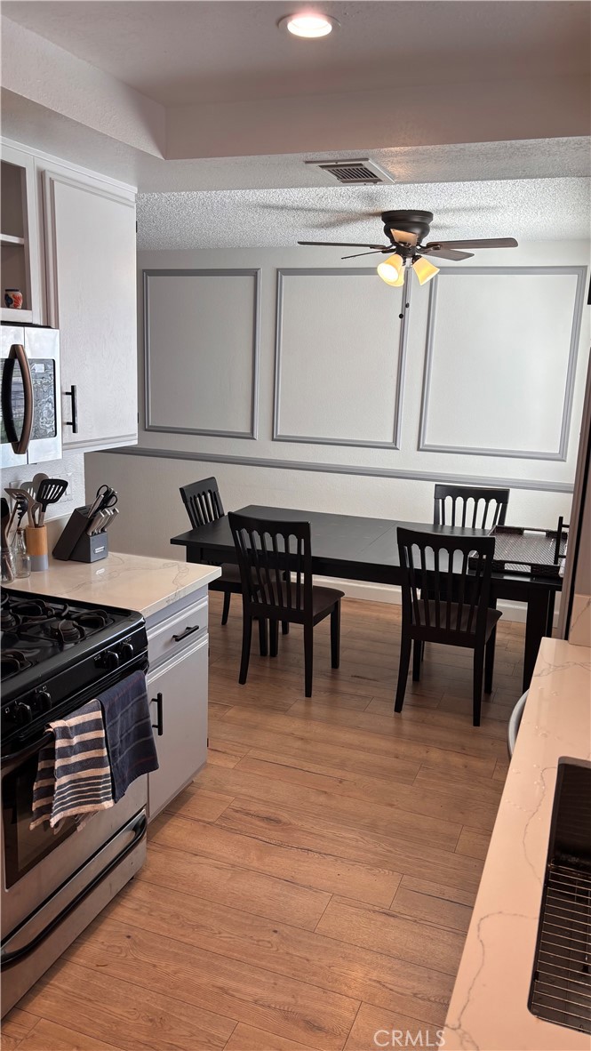 103 West Spring Street, Unit A Long Beach, CA 90806 - Photo 6 of 27 a kitchen with a stove a sink and a microwave