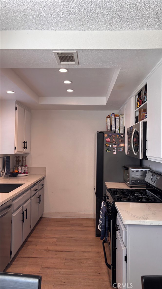103 West Spring Street, Unit A Long Beach, CA 90806 - Photo 9 of 27 a kitchen with a sink cabinets and wooden floor