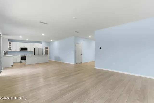 a large kitchen with kitchen island a sink a center island stainless steel appliances and a cabinets