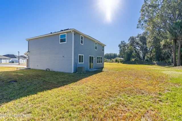 an aerial view of a house with swimming pool and outdoor seating