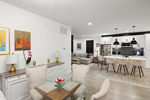 a living room with furniture and a dining table with kitchen view