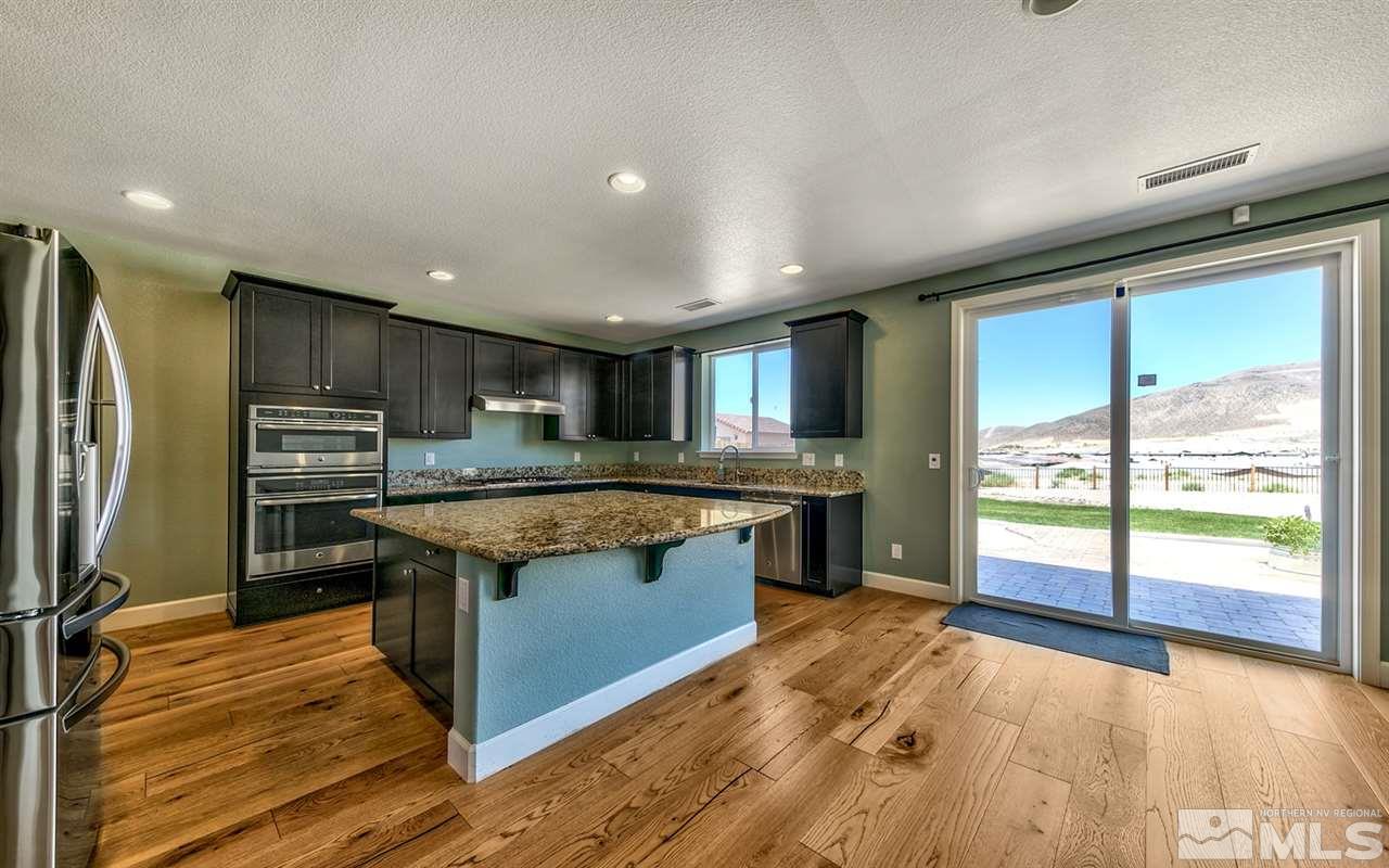 2985 Bull Rider Drive Reno, NV 89521 - Photo 5 of 16 a kitchen with stainless steel appliances granite countertop a refrigerator a sink dishwasher a stove and a large countertops with wooden floor