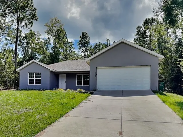 a front view of house with yard and trees around