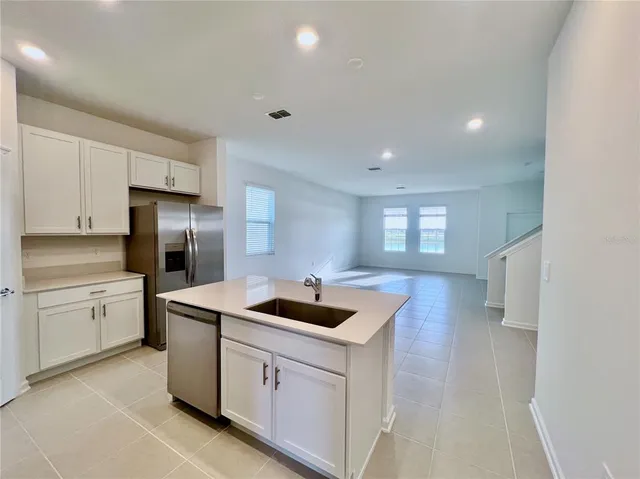 a kitchen that has a sink a stove and refrigerator