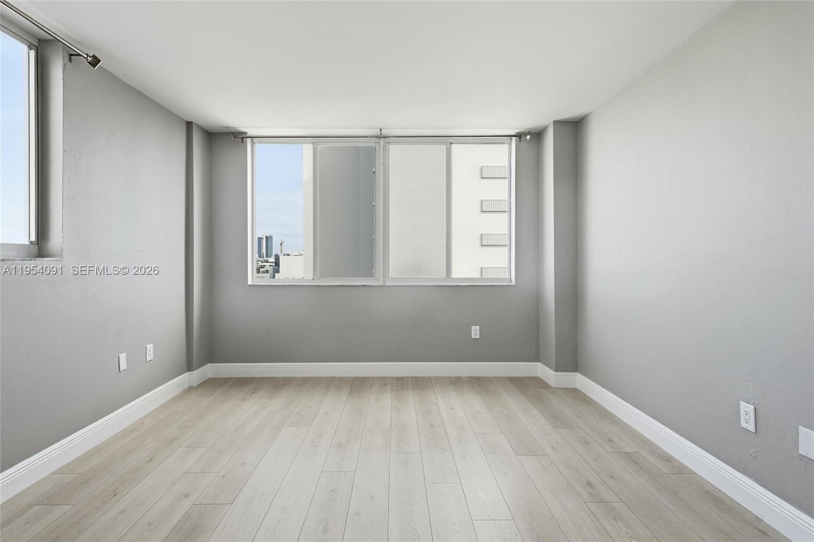 1345 Lincoln Road, Unit 1006 Miami Beach, FL 33139 - Photo 11 of 27 an empty room with wooden floor and windows