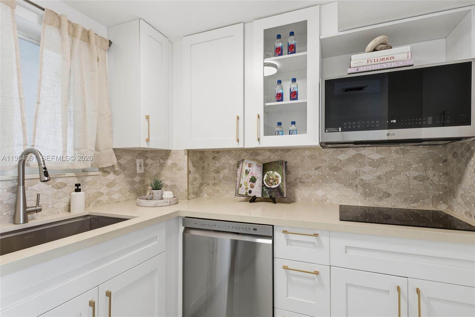 1345 Lincoln Road, Unit 1006 Miami Beach, FL 33139 - Photo 6 of 27 a kitchen with stainless steel appliances white cabinets and a sink