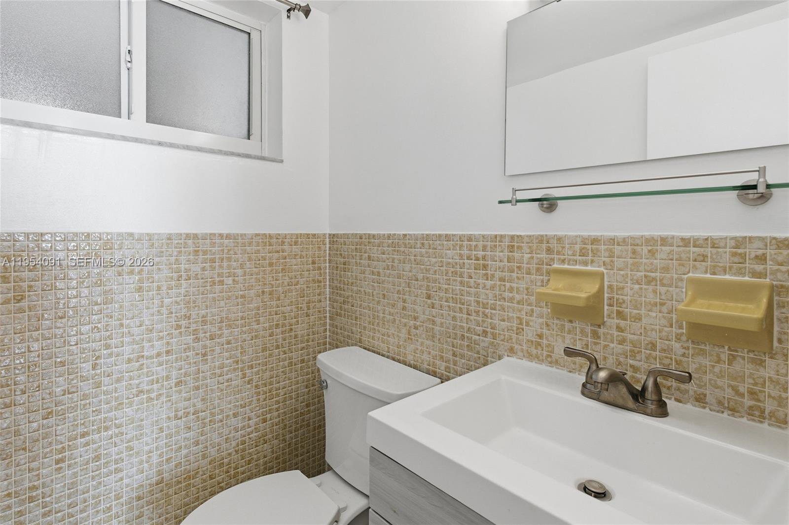 1345 Lincoln Road, Unit 1006 Miami Beach, FL 33139 - Photo 9 of 27 a bathroom with a sink a toilet and mirror