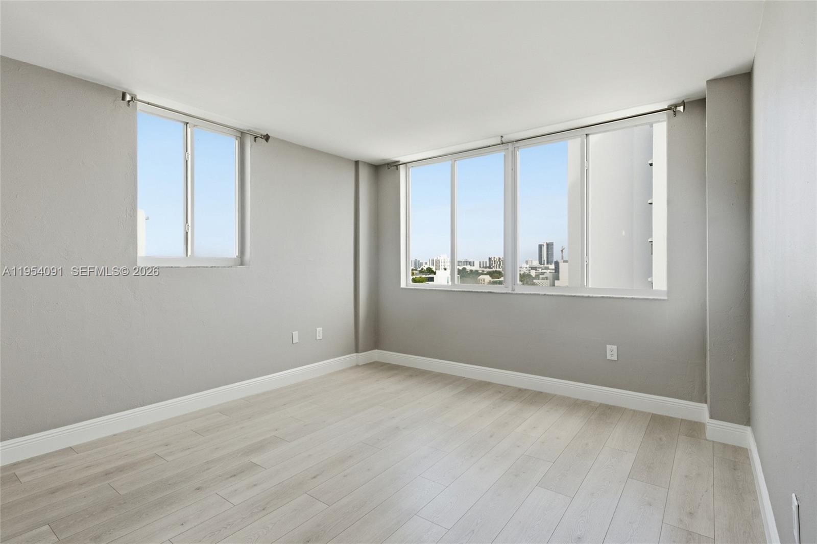 1345 Lincoln Road, Unit 1006 Miami Beach, FL 33139 - Photo 10 of 27 a view of an empty room with wooden floor and a window
