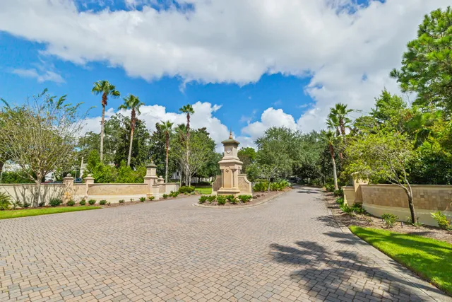 a front view of a multi story residential apartment building with yard and potted plants