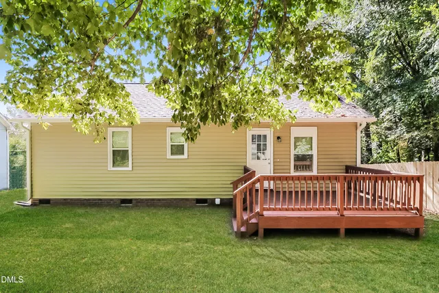a view of a house with a backyard and deck
