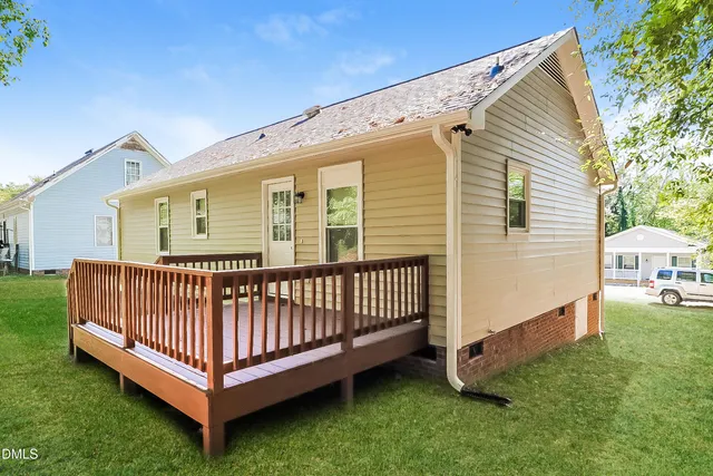 a view of a house with a yard and deck
