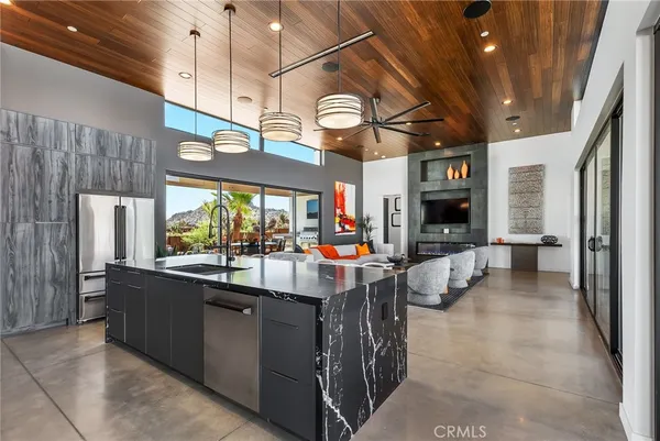 a kitchen with a stove a sink and a dining table with wooden floor