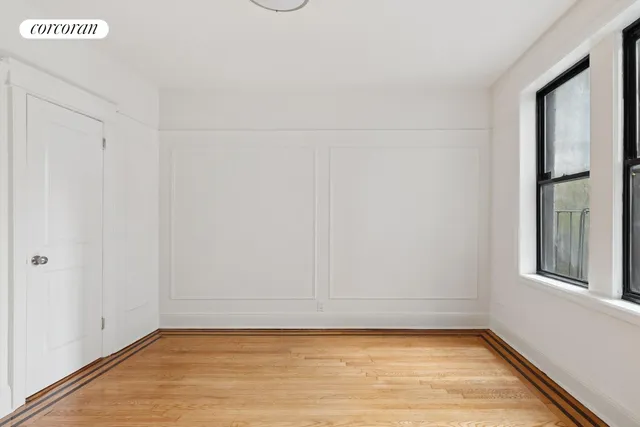a view of a small space with wooden floor and a window