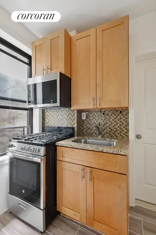 a kitchen with stainless steel appliances granite countertop a stove a sink and a microwave