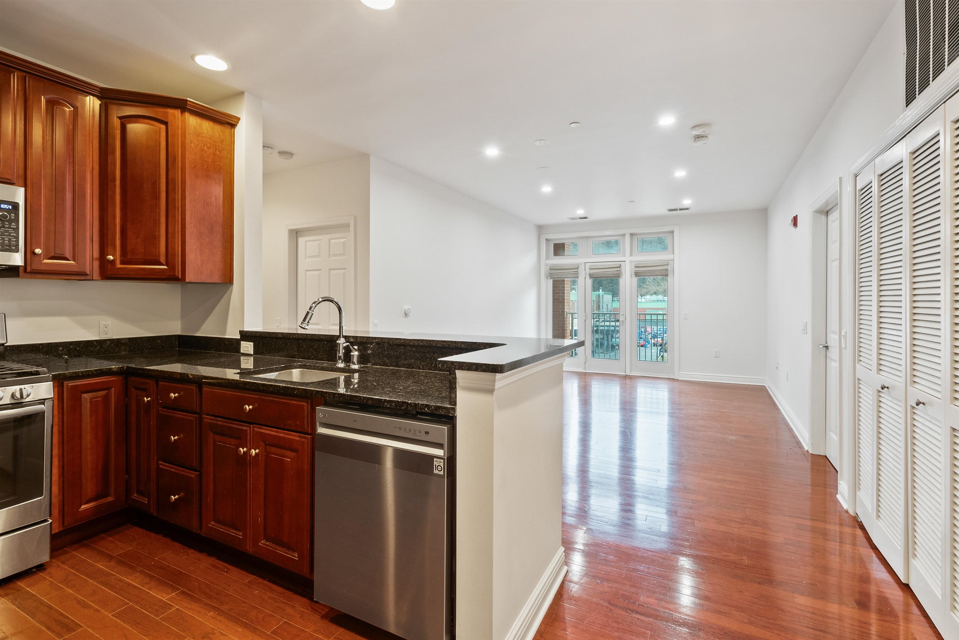 7400 River Road, Unit 317 North Bergen, NJ 07047 - Photo 2 of 41 a kitchen with stainless steel appliances granite countertop a sink and wooden cabinets with wooden floors