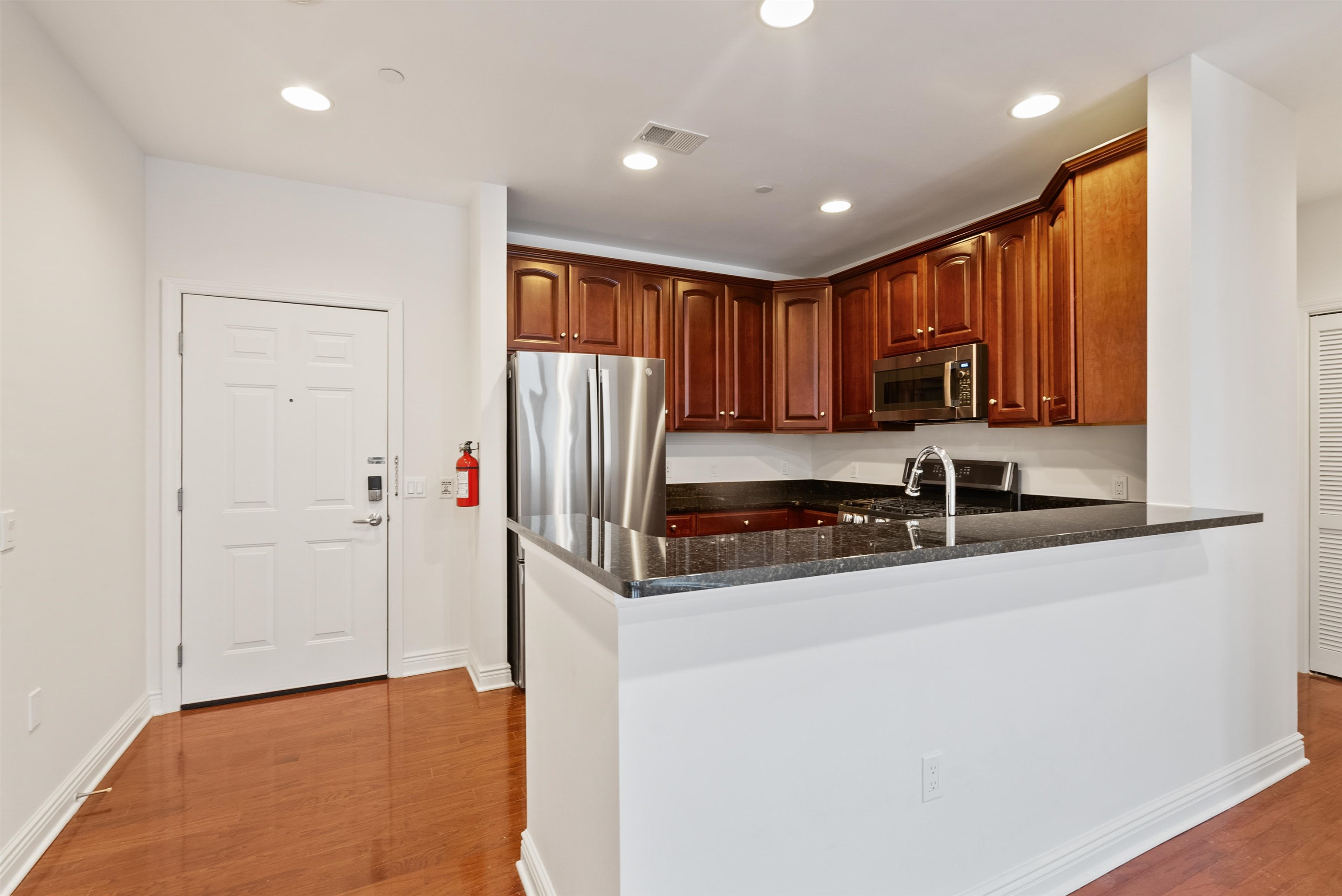 7400 River Road, Unit 317 North Bergen, NJ 07047 - Photo 6 of 41 a kitchen with stainless steel appliances granite countertop a refrigerator a sink and a stove